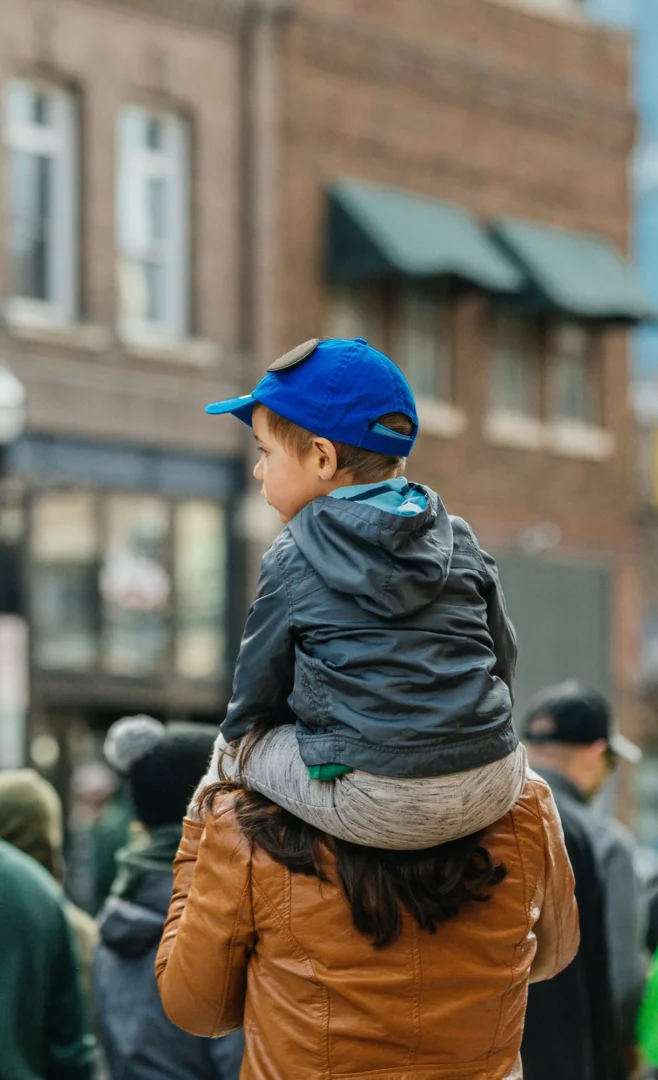 a child sitting on a woman's shoulders.